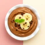 Chocolate banana nice cream in vintage bowl topped with banana slices